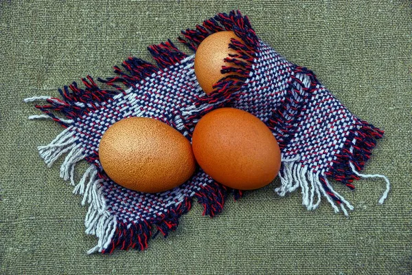 Three brown eggs in a woolen shawl