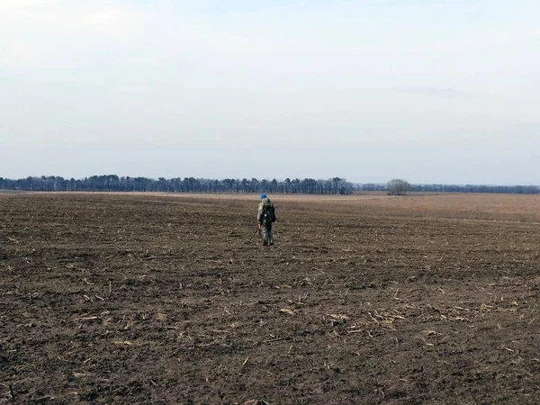 Man with a metal detector in the field