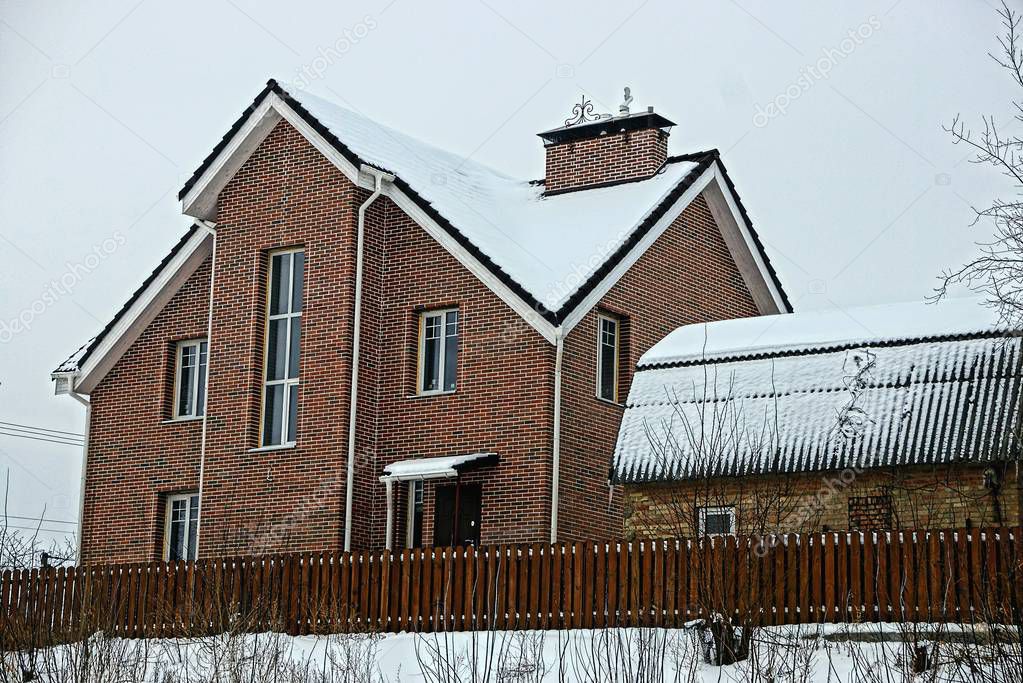 brown brick apartment building with snow on the roof