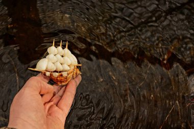 Adam su üzerinde bir el oyuncak tekne başlar