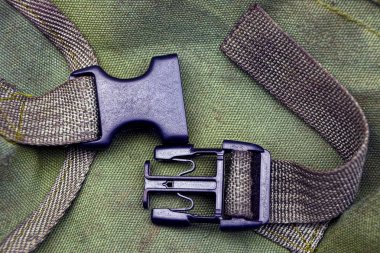 bir sırt çantası nın kumaşı üzerinde yeşil koşumlar üzerinde siyah açık plastik karabina