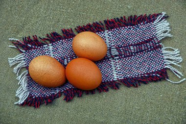 üç kahverengi tavuk yumurtası yeşil bir masa üzerinde renkli bir yün peçete üzerinde yalan