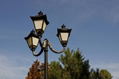 mavi gökyüzüne karşı bir kutup üzerinde üç eski siyah fenerler