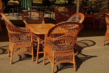 Asfalt üzerinde Hasır kahverengi masa ve sandalyeler