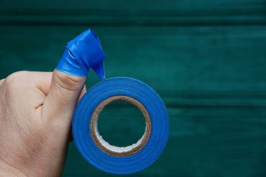 Blue insulating tape wound on the finger of the hand clipart
