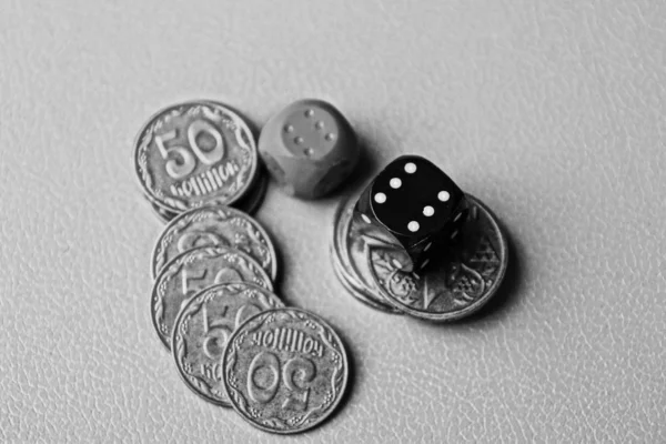 在桌子上的一堆硬币上切骰子 — 图库照片
