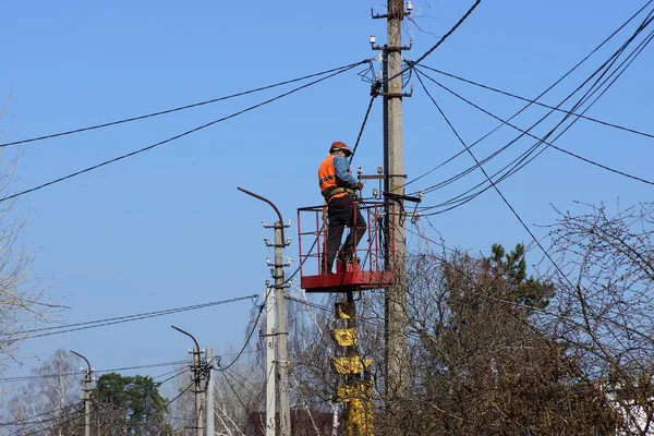 Elektrikçi direğin kablolarını değiştiriyor.