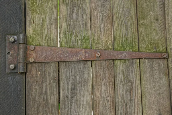 Paslı kahverengi kapı menteşesi Gri ahşap çit tahtalarında