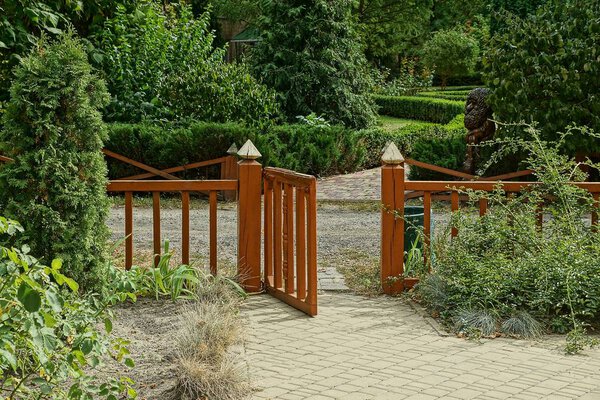 decorative brown open door made of boards on a gray sidewalk