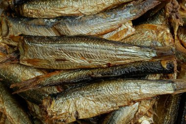 food from a heap of smoked small fish sprats