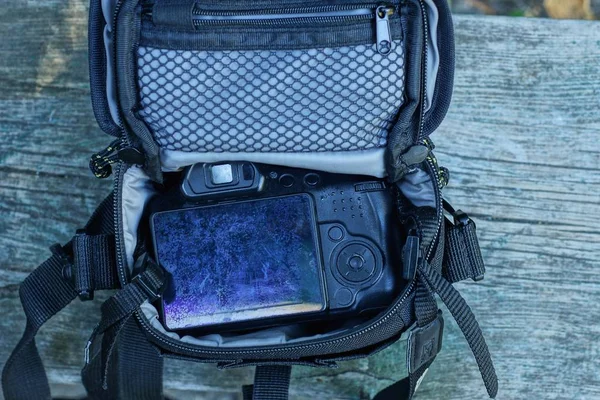 Una Macchina Fotografica Nera Trova Una Borsa Aperta Grigia Tavolo — Foto Stock