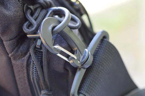 black metal latch on a harness made of fabric on a bag