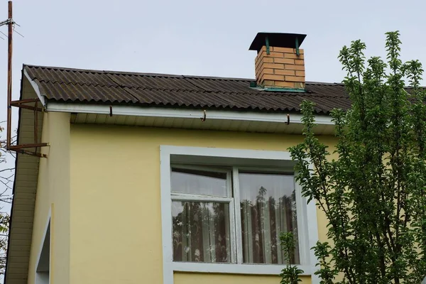 Gelber Dachboden Eines Privathauses Mit Weißem Fenster Unter Grauem Schieferdach — Stockfoto