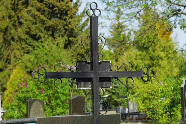 Uma Cruz Ferro Preto Cemitério Entre Árvores Verdes — Fotografia de Stock