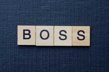  text on word boss from gray wooden letters on a black background