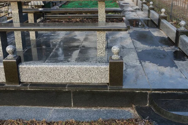 Část Šedého Mramorového Plotu Stojí Černých Mokrých Deskách Hrobu Hřbitově — Stock fotografie