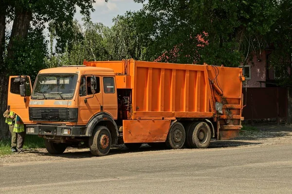 Grande Caminhão Laranja Coletor Lixo Fica Uma Estrada Asfalto Rua — Fotografia de Stock