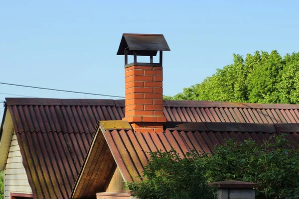 民家の屋根の上にある茶色のレンガの煙突が — ストック写真