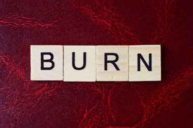  Kırmızı bir masanın üzerinde siyah yazı tipi olan gri ahşap harflerden yak sözcüğünü yaz.