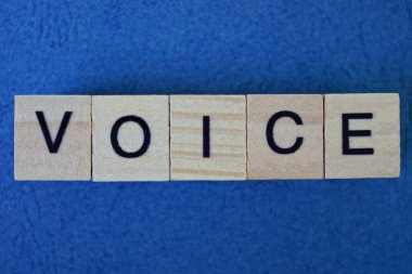  Mavi arkaplanda siyah yazı tipi olan küçük ahşap harflerle gri kelime sesi üzerine metin