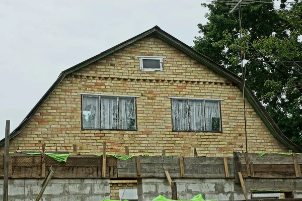 灰色の空に2つの窓がある古い民家の茶色のレンガ造りのロフト — ストック写真