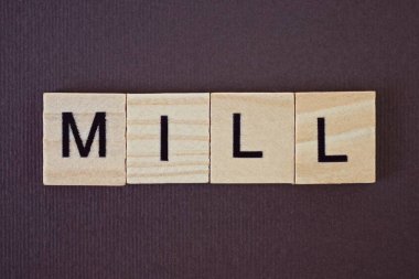 Kahverengi arka planda ahşap kare harflerden yapılmış gri kelime değirmeni