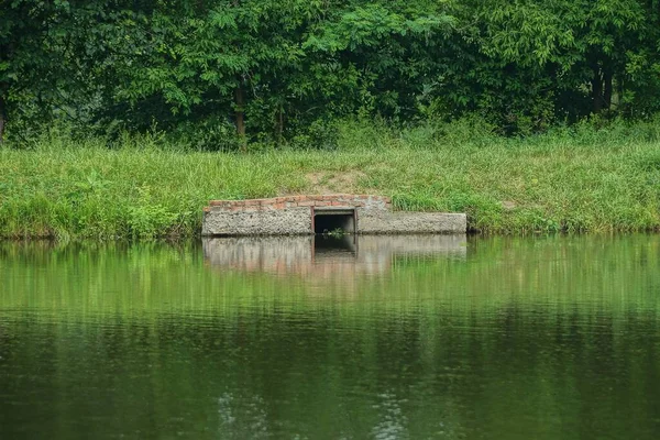 Одна Сіра Стара Бетонна Гребля Воді Ставка Березі Зеленій Траві — стокове фото