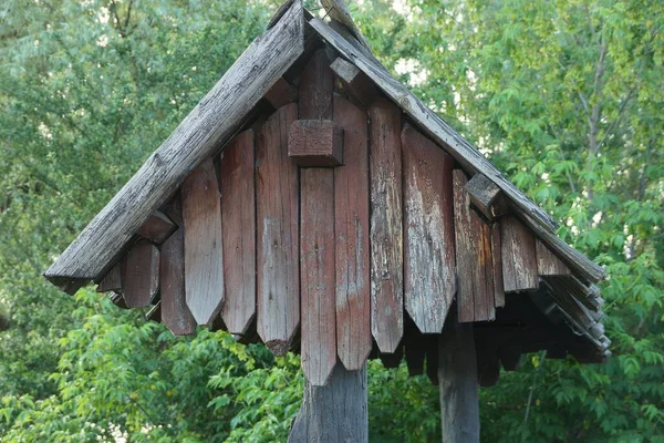 通りの緑の植生を背景に板から古い灰色の茶色の木製の屋根 — ストック写真