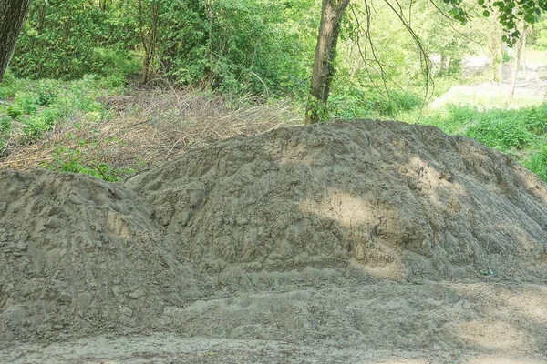 Велика Купа Сірого Піску Зовні Серед Зеленої Рослинності — стокове фото