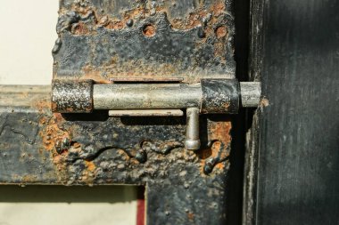 Gri, kapalı bir metal kapı mandalı. Sokakta siyah demir bir kapı.