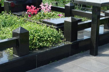  Mezarlıktaki gri taş bir taşın üzerindeki siyah mermer çit.