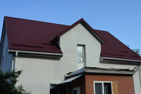 青い空に向かって赤い瓦屋根の下にガラスのドアを持つ白い民家の屋根裏部屋 — ストック写真