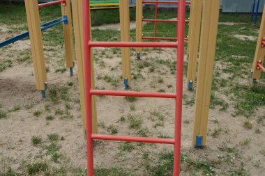 Oyun parkındaki kırmızı metal bir merdivenin parçası.