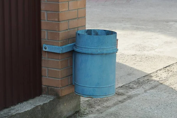 Одна Голубая Железная Урна Висит Кирпичной Стене Снаружи — стоковое фото