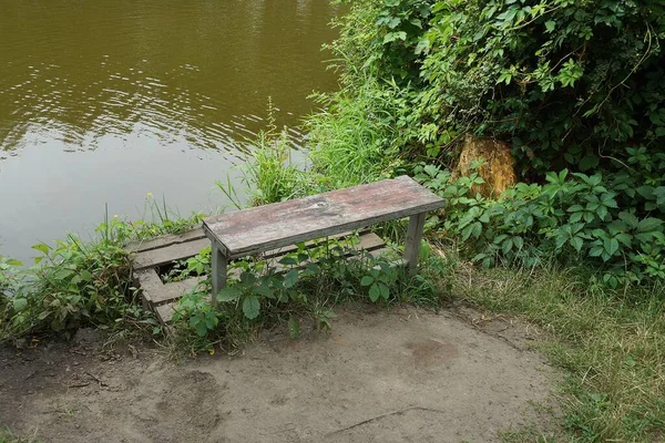 Een Grijze Houten Bank Staat Een Oude Brug Groen Gras — Stockfoto