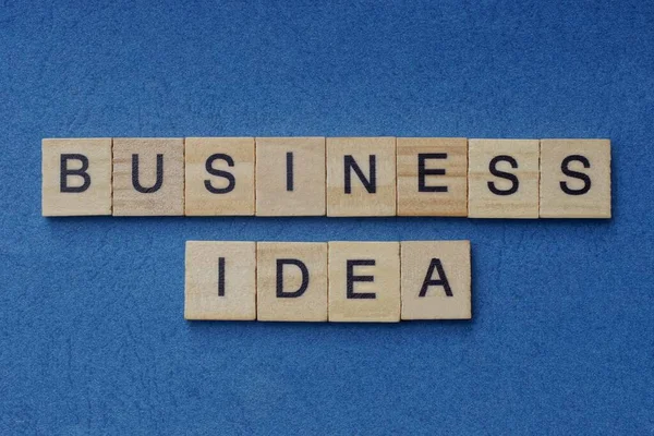 青い背景に黒いフォントの小さな正方形の木製の文字でフレーズビジネスのアイデア — ストック写真