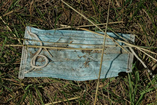 Lixo Uma Máscara Médica Azul Sujo Encontra Chão Marrom Grama — Fotografia de Stock