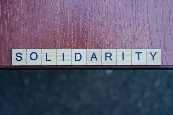 Palavra Solidariedade Feita Letras Quadradas Madeira Mesa Marrom Fundo Cinza — Fotografia de Stock