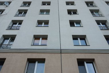 Bir evin gri duvarındaki bir sıra pencerenin dokusu