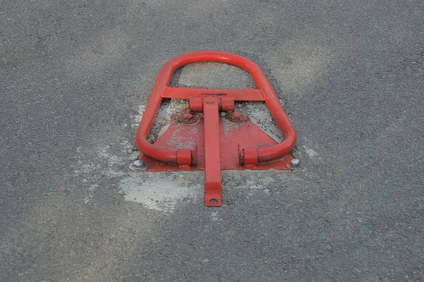 在停车场的道路灰蒙蒙的沥青路面上 有一个红色的金属联锁 — 图库照片