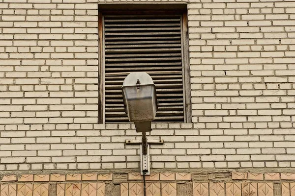 Egy Régi Szürke Fém Lámpás Egy Téglafalon Egy Ablakkal Redőnyökkel — Stock Fotó