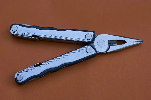 Multitool Gris Del Metal Miente Una Tabla Marrón —  Fotos de Stock