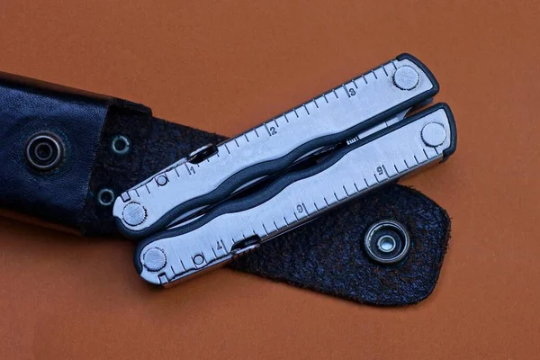 Multitool Metallo Grigio Custodia Pelle Nera Trovano Sullo Sfondo Marrone — Foto Stock