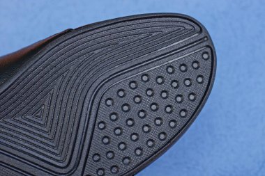 Mavi arka planda siyah desenli lastik tabanlı botun bir parçası.