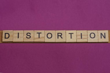 Tahta harflerden yapılmış kelime çarpıtılması bir leylak masasında yatıyor.