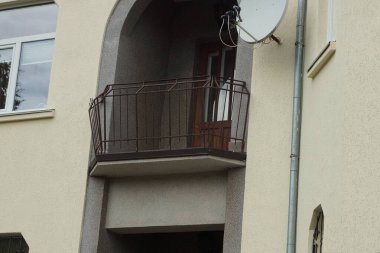 Kahverengi bir duvarda demirden yapılmış açık metal bir balkon.