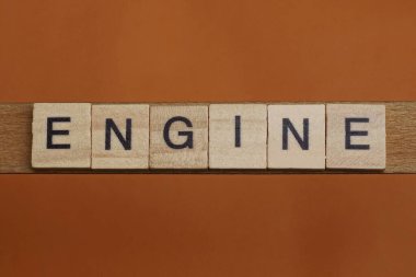 Kahverengi arkaplanda tahta kare harflerden oluşan gri kelime motoru