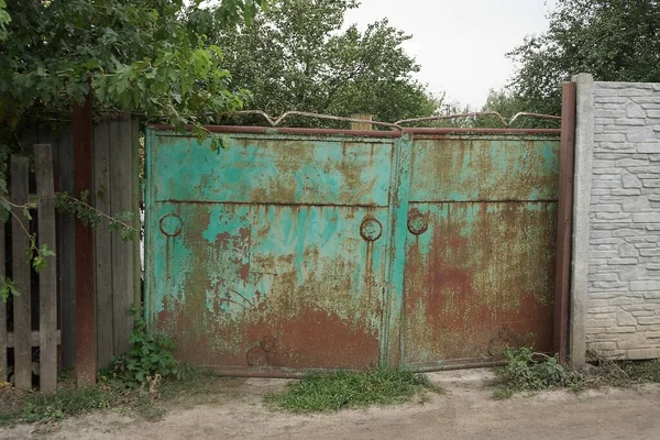 乡村街道上褐色铁锈的旧紧闭的绿色铁门 — 图库照片