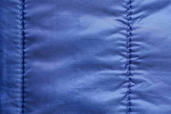 青の合成繊維の背景の服から砕いた布の断片 — ストック写真