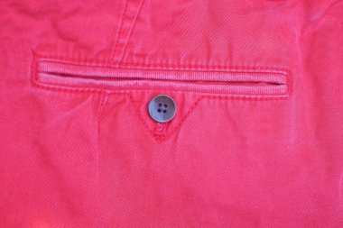 Kırmızı kumaşın cebinde kahverengi bir düğme.